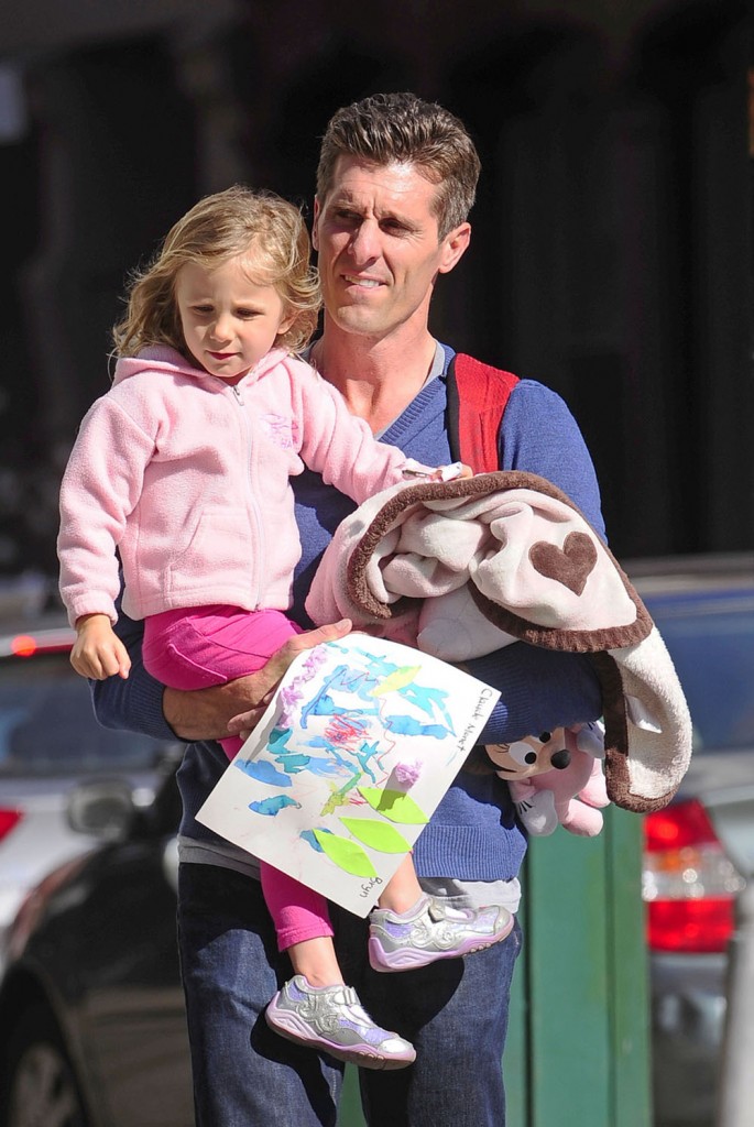 Jason Hoppy carries baby daughter Bryn Hoppy after picking her up from school in Tribeca, New York City