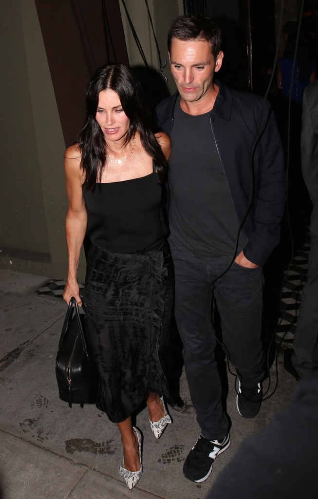 Courteney Cox shows off her engagement ring as she and her fiance Johnny McDaid leave Craig's in West Hollywood