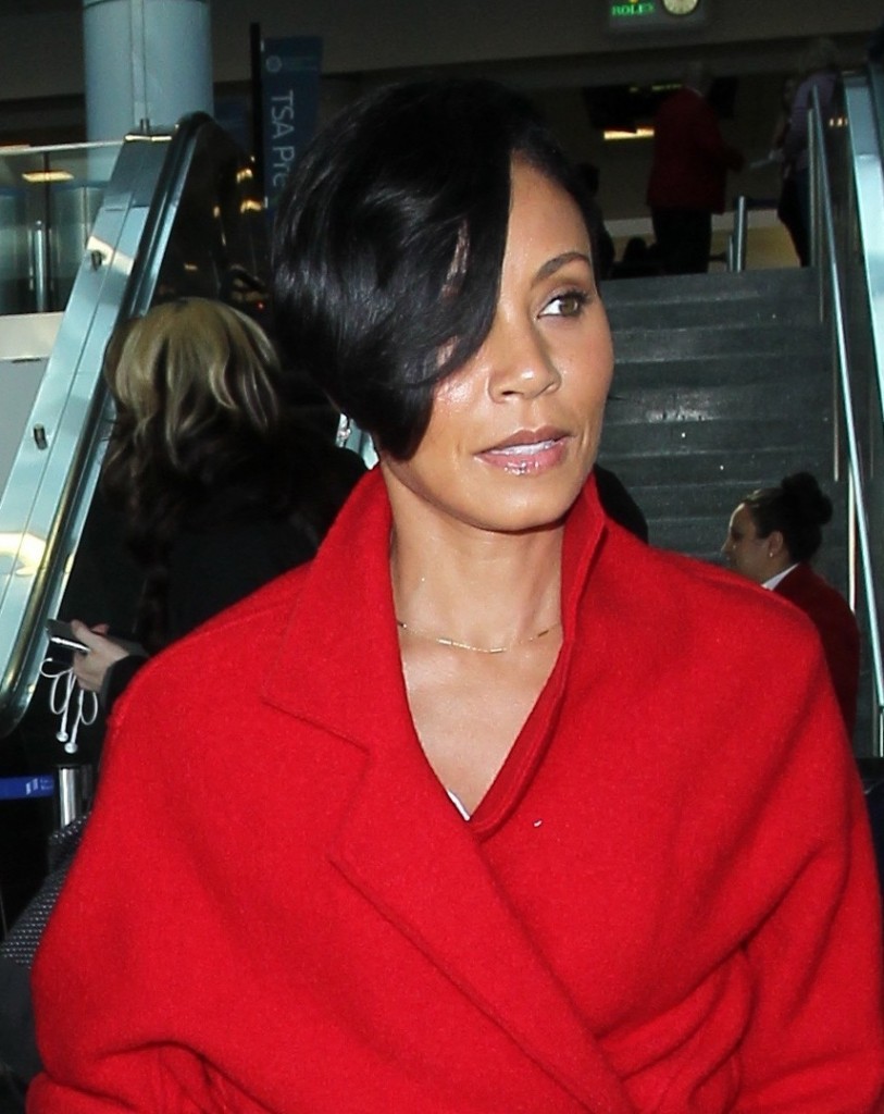 Jada Pinkett Smith arrives at LAX in a bold full length red coat