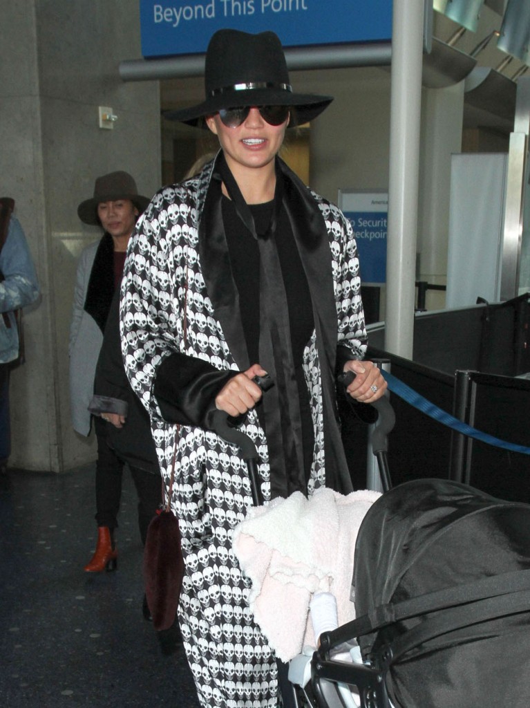 Chrissy Teigen & Daughter Arriving On A Flight At LAX