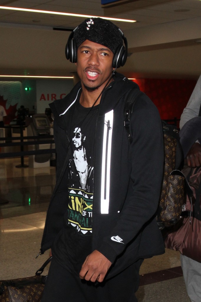 Nick Cannon arrives at LAX carrying a Louis Vuitton duffle bag
