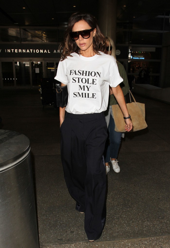 Victoria Beckham wears one of her own designs - a tongue in cheek t-shirt with the slogan 'Fashion Stole My Smile' - as she makes her way through LAX