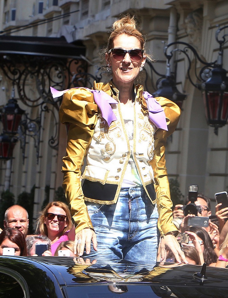 Celine Dion waves to fans as she leaves the Royal Monceau Hotel