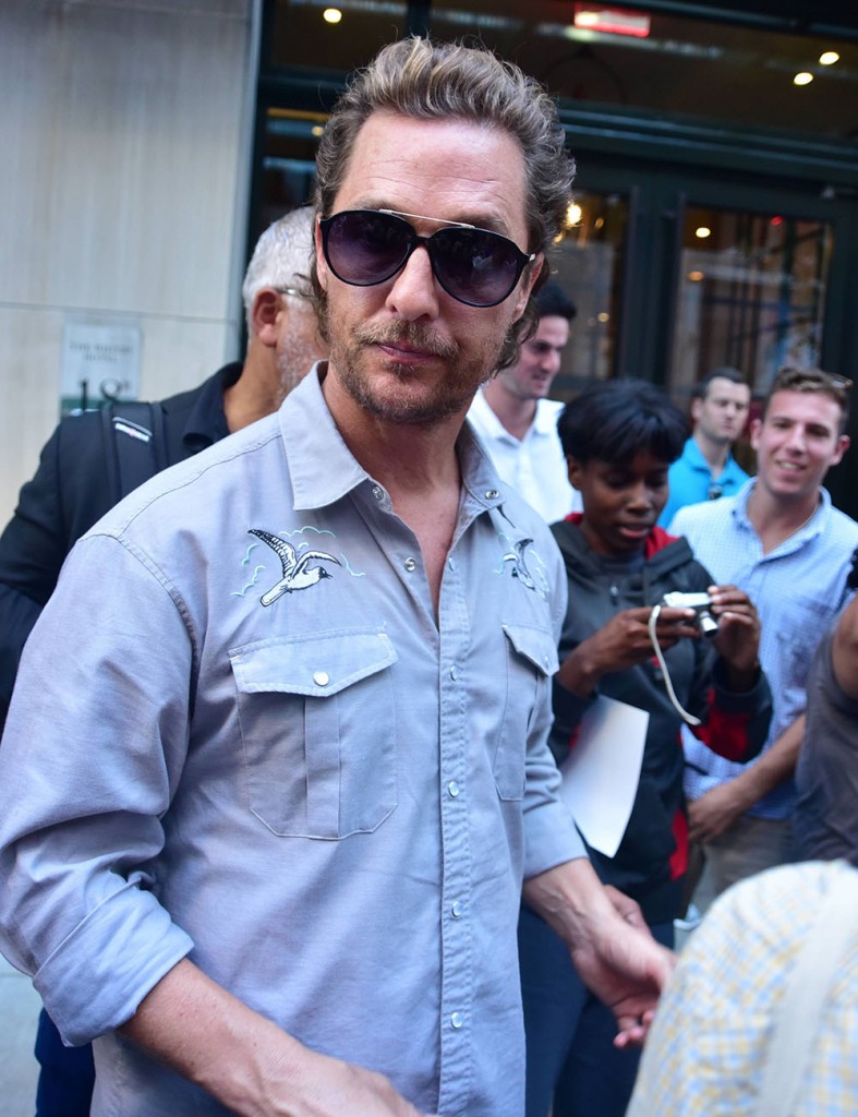 Matthew McConaughey signs autographs for fans as he leaves a Dark Tower press junket