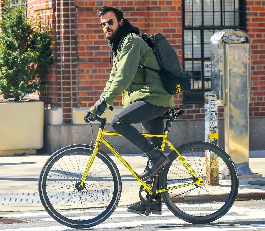 Newly-single Justin Theroux pedals through traffic on his gold fixed-gear bike