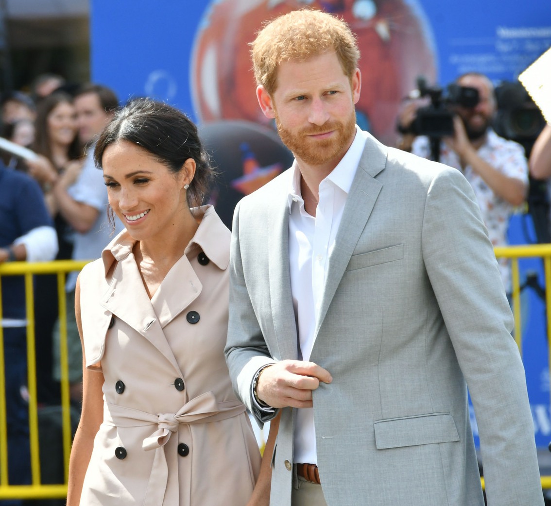 Meghan, Duchess of Sussex, wears a pale pink trench dress by House of Nonie as she visits the Nelson Mandela Centenary Exhibition at the Southbank Centre's Queen Elizabeth Hall in London with husband Prince Harry, Duke of Sussex