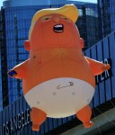 A giant 'Baby Trump' inflatable, an enormous balloon that depicts President Trump as a yellow-haired, diaper-clad baby holding a cell phone, is launched over the Los Angeles Convention Center, the site of the weekend Politicon convention