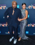Kim Kardashian and Kanye West pose on the black carpet during Cher's opening night