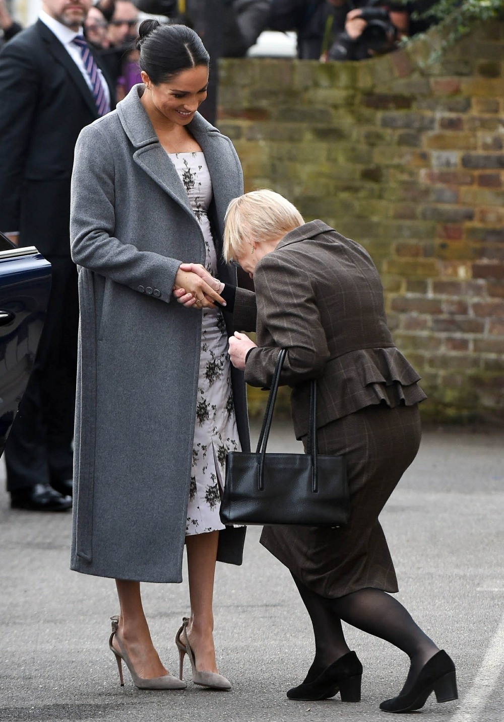 Meghan Markle shows off growing baby bump while making a visit to the Royal Variety care home