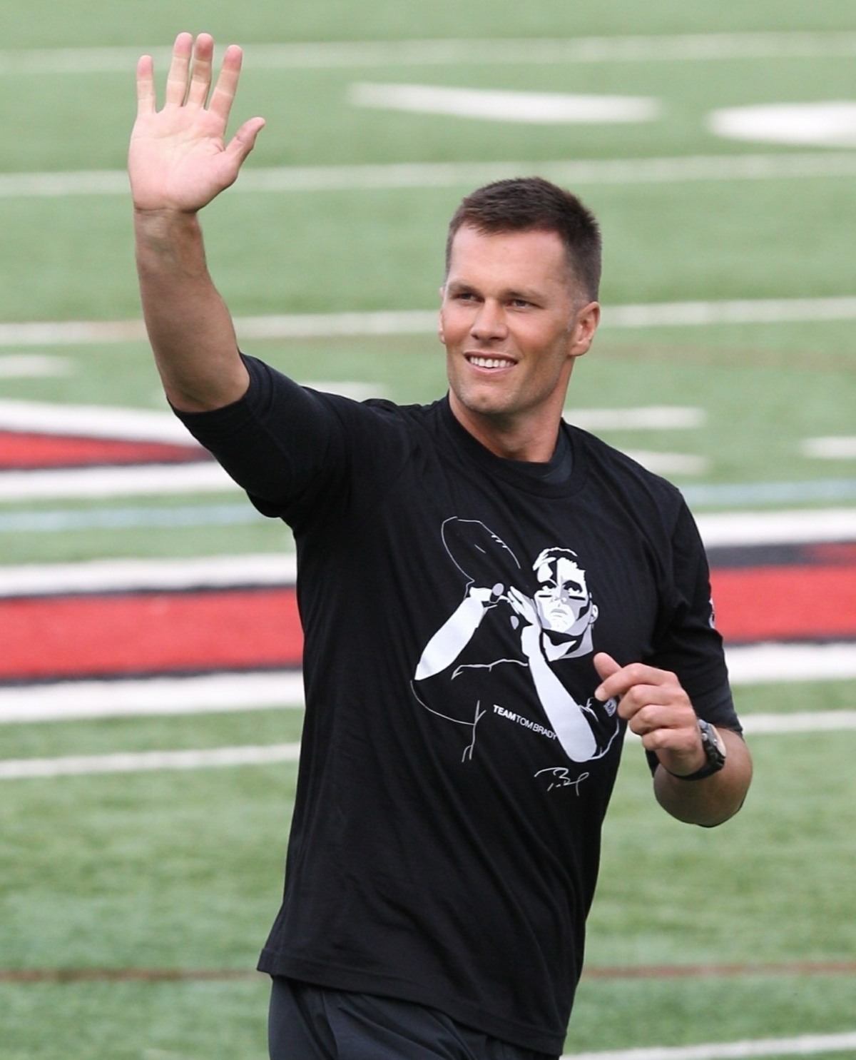 Tom Brady plays football with his sons at the Harvard University Best Buddies event