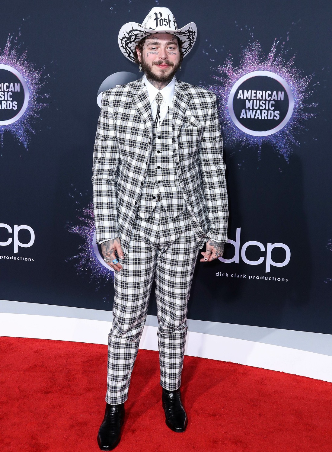 Rapper Post Malone wearing a Charbel Zoe dress arrives at the 2019 American Music Awards held at Microsoft Theatre L.A. Live on November 24, 2019 in Los Angeles, California, United States.