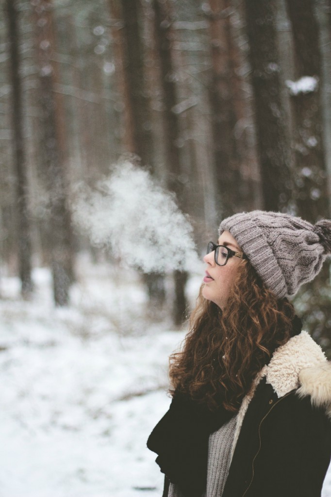 woman-standing-and-smoking-on-snow-covered-forest-2182190