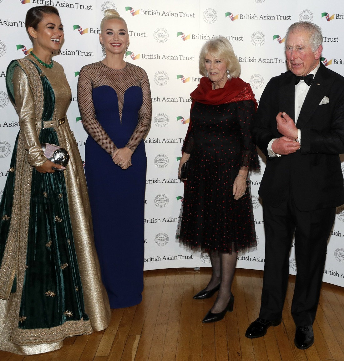 Britain's Prince Charles, Royal Founding Patron of the British Asian Trust, and his wife Camilla, Duchess of Cornwall, meet musician American Katy Perry, second left, and Indian businesswoman Natasha Poonawalla, left, as they arrive to attend a reception for supporters of the British Asian Trust in London, Tuesday, Feb. 4, 2020.