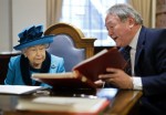 Britain's Queen Elizabeth II is shown documents as she visits the new headquarters of the Royal Philatelic society in London on November 26, 2019.