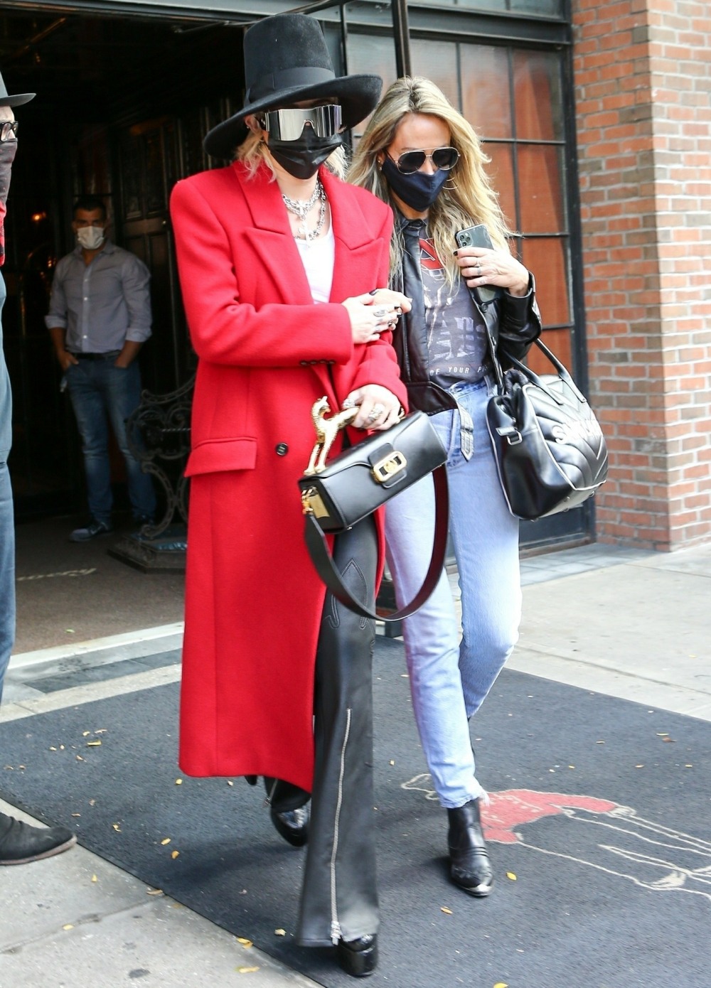 Miley Cyrus rocks a red trench coat as she steps out of her hotel
