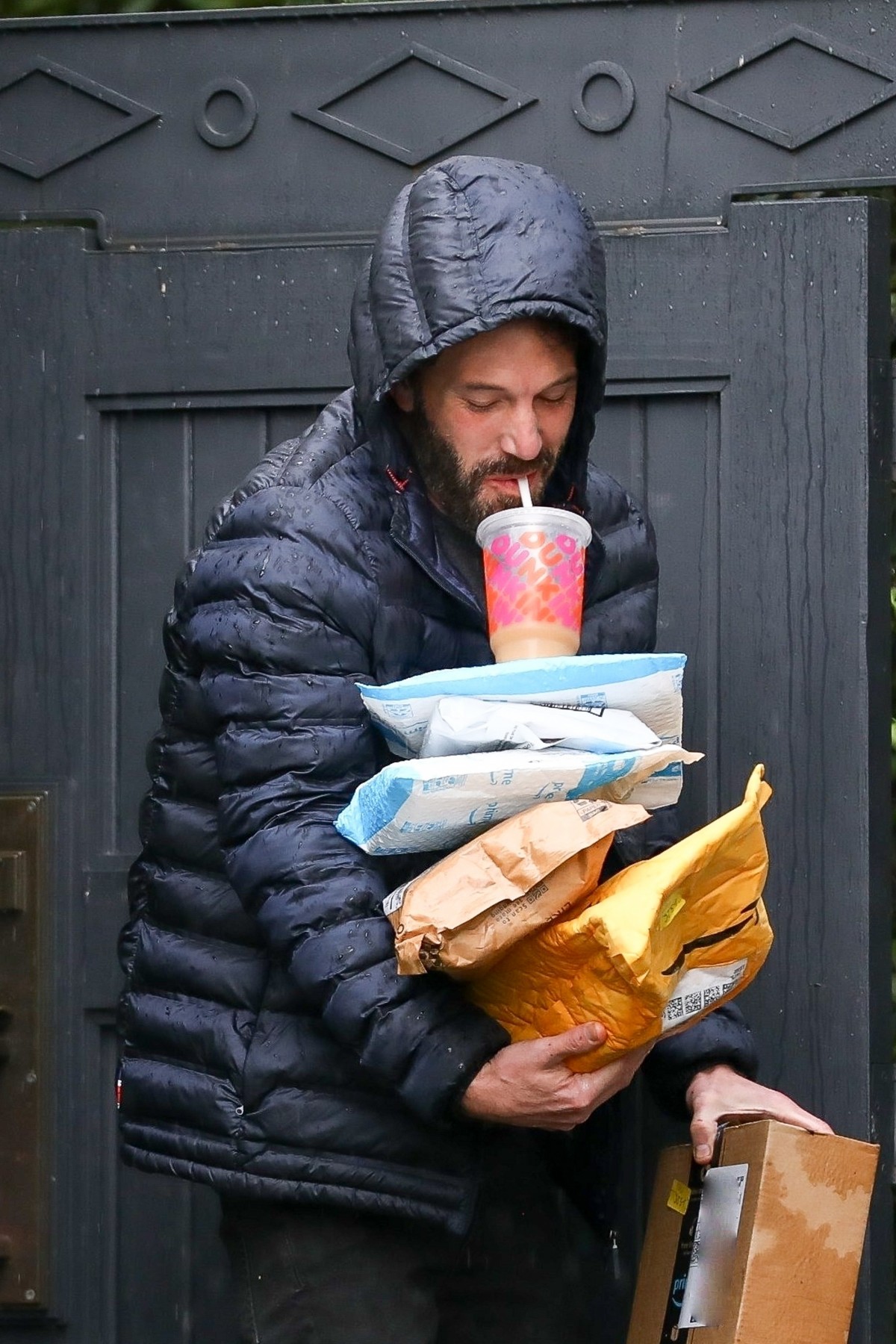 Ben Affleck grabs packages that were delivered to his house while sipping his coffee