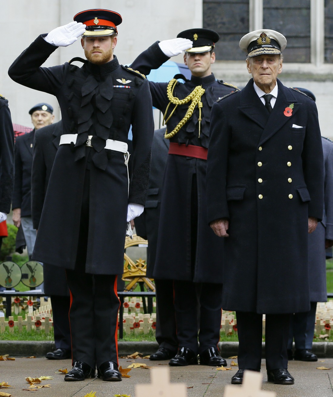 Britain's Prince Harry, left, salutes next to The Duke of Edinburgh during a visit to the Field of Remembrance at Westminster Abbey in London, Thursday, Nov. 5, 2015. The Duke of Edinburgh and Prince Harry each placed a Cross of Remembrance for Unknown Br
