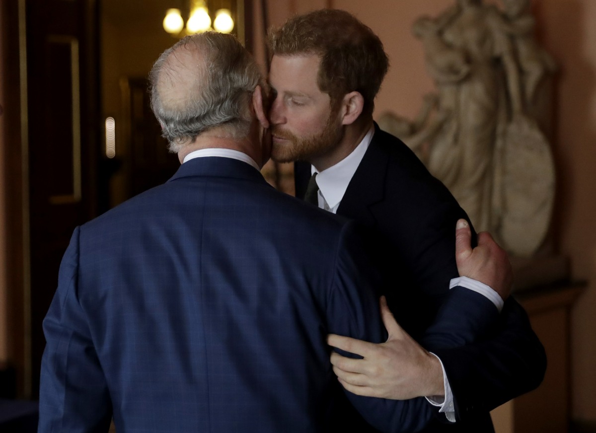 Britain's Prince Harry kisses and greets his father Prince Charles upon their separate arrival to attend a coral reef health and resilience meeting with speeches and a reception with delegates at Fishmongers Hall in London, Wednesday, Feb. 14, 2018. The e