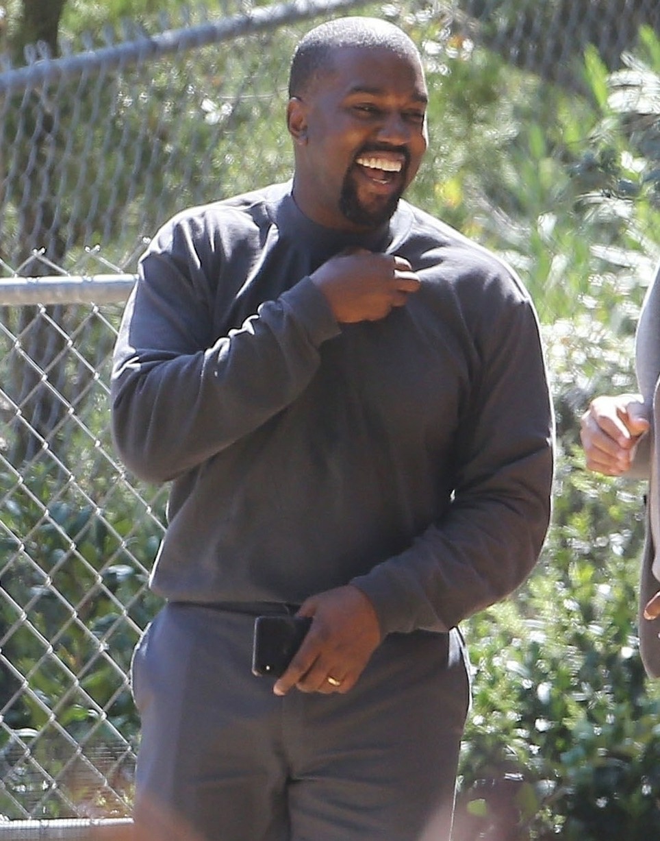 Kanye West looks cheerful as he chats with friends after his church service