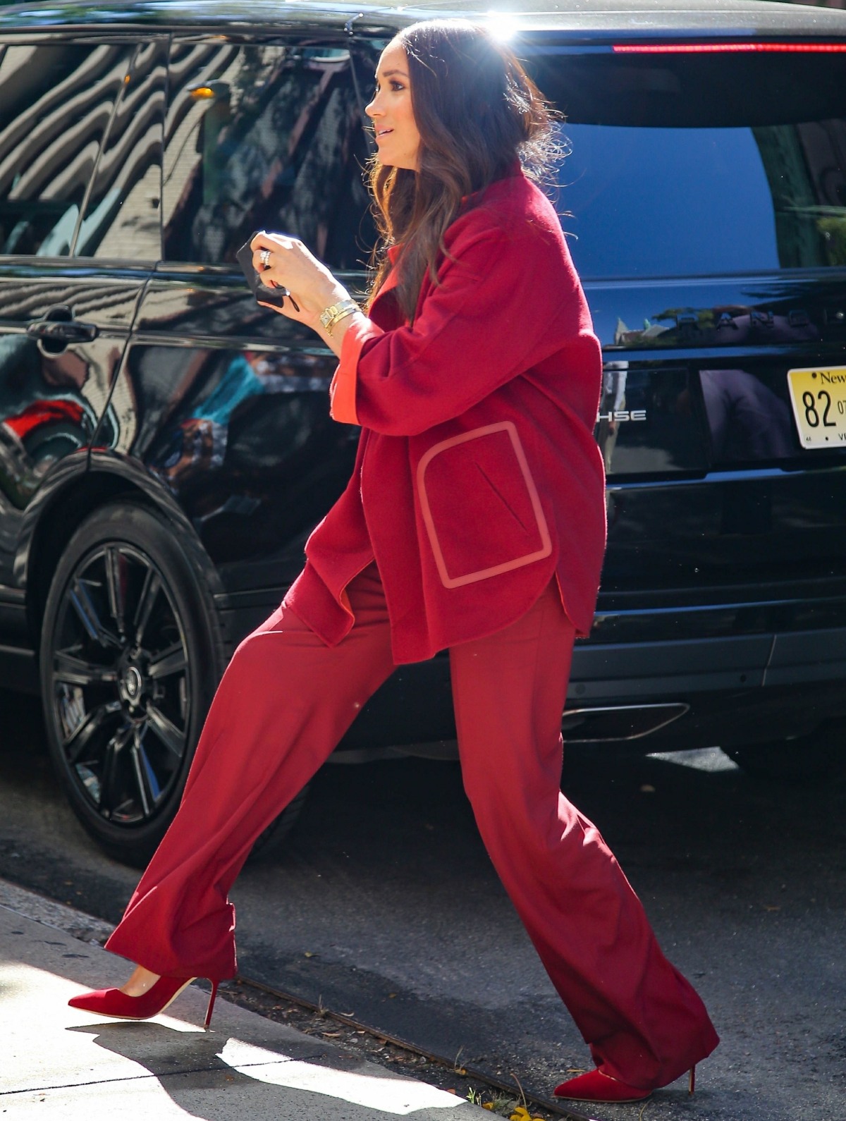 Meghan Markle looks stylish in a red velvet suit as she arrives at a Harlem elementary school