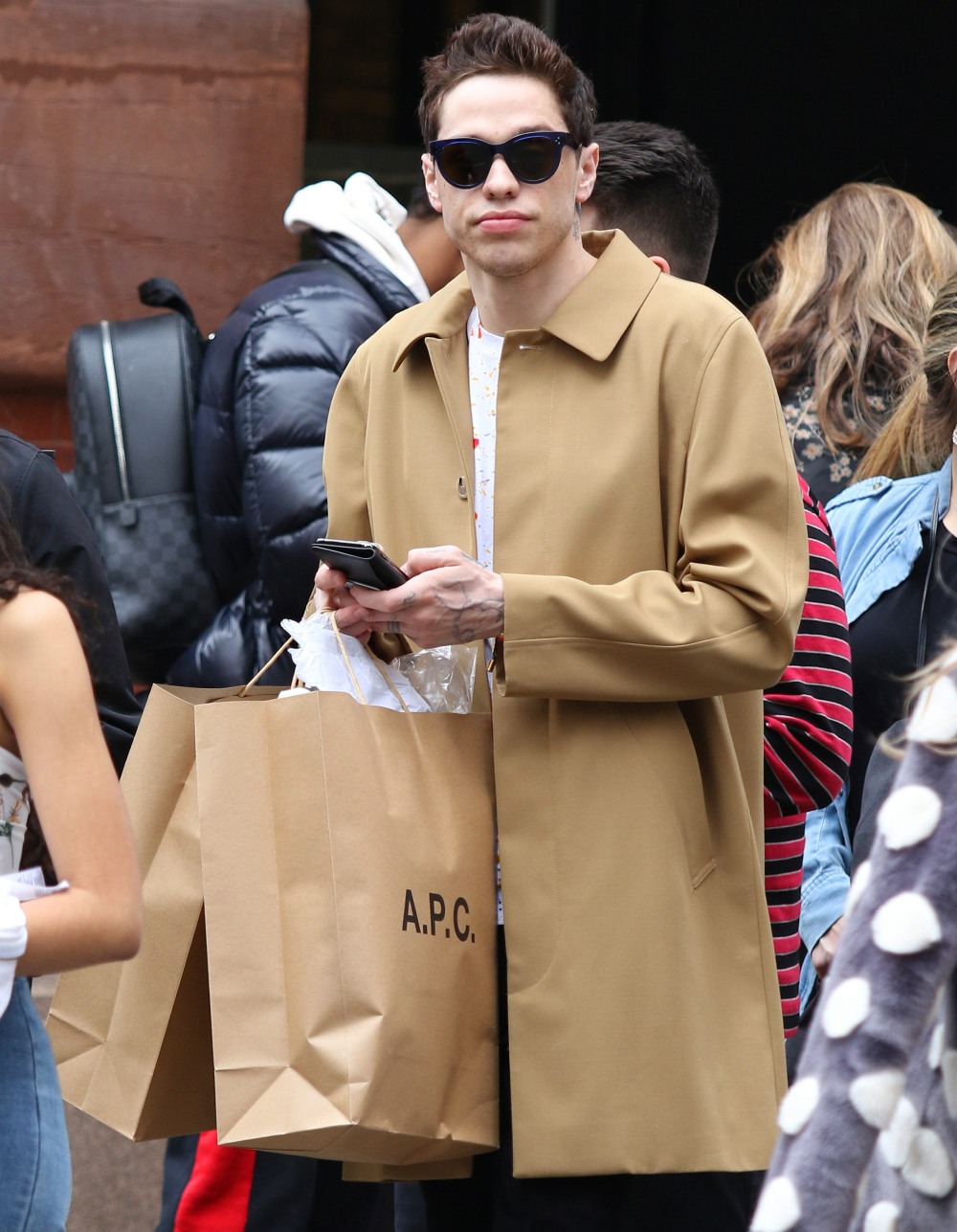 Pete Davidson checks his phone as he spends the afternoon shopping with friends around Manhattan's Soho area
