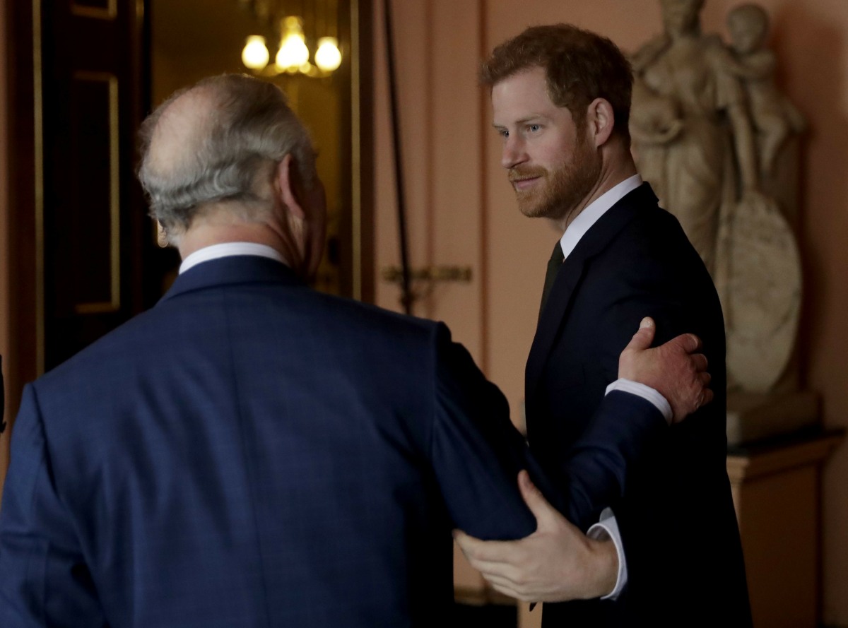 Britain's Prince Harry greets his father Prince Charles upon his separate arrival to attend a coral reef health and resilience meeting with speeches and a reception with delegates at Fishmongers Hall in London, Wednesday, Feb. 14, 2018. The event held Wed