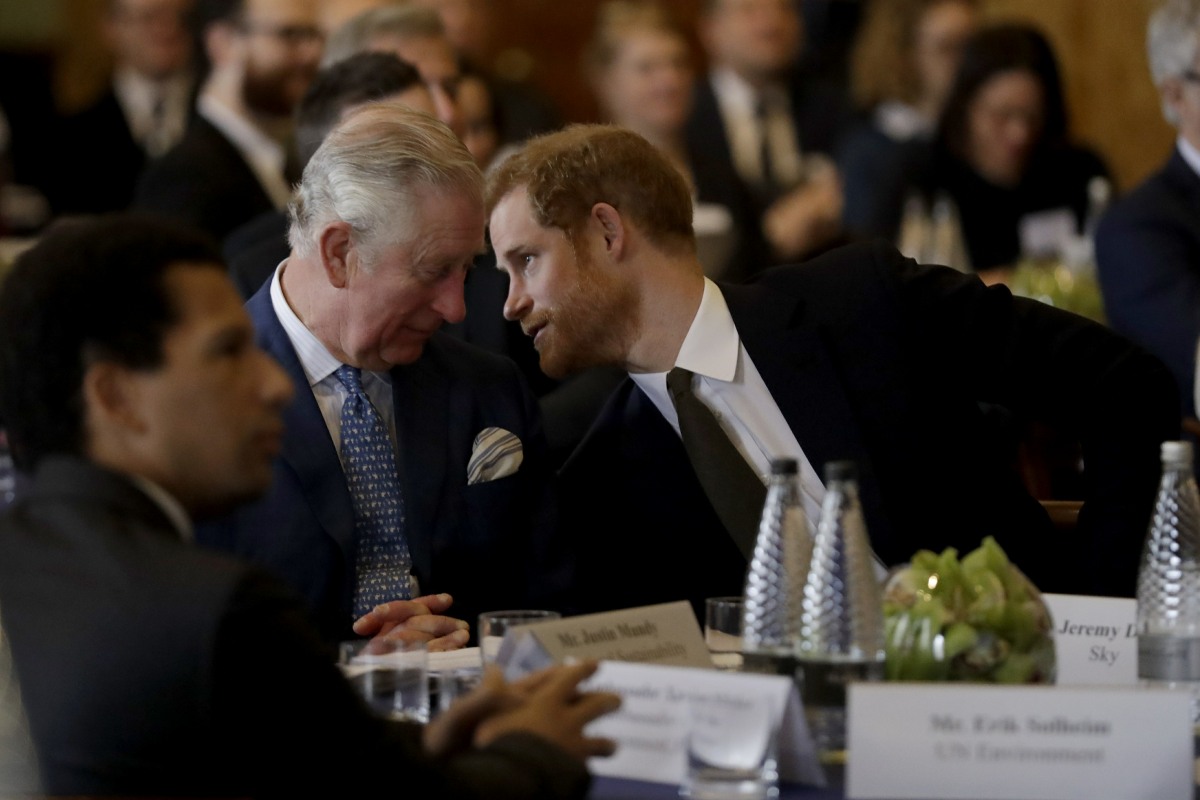 Britain's Prince Harry leans over to speak with his father Prince Charles in accompanying him to attend a coral reef health and resilience meeting with speeches and a reception with delegates at Fishmongers Hall in London, Wednesday, Feb. 14, 2018. The ev