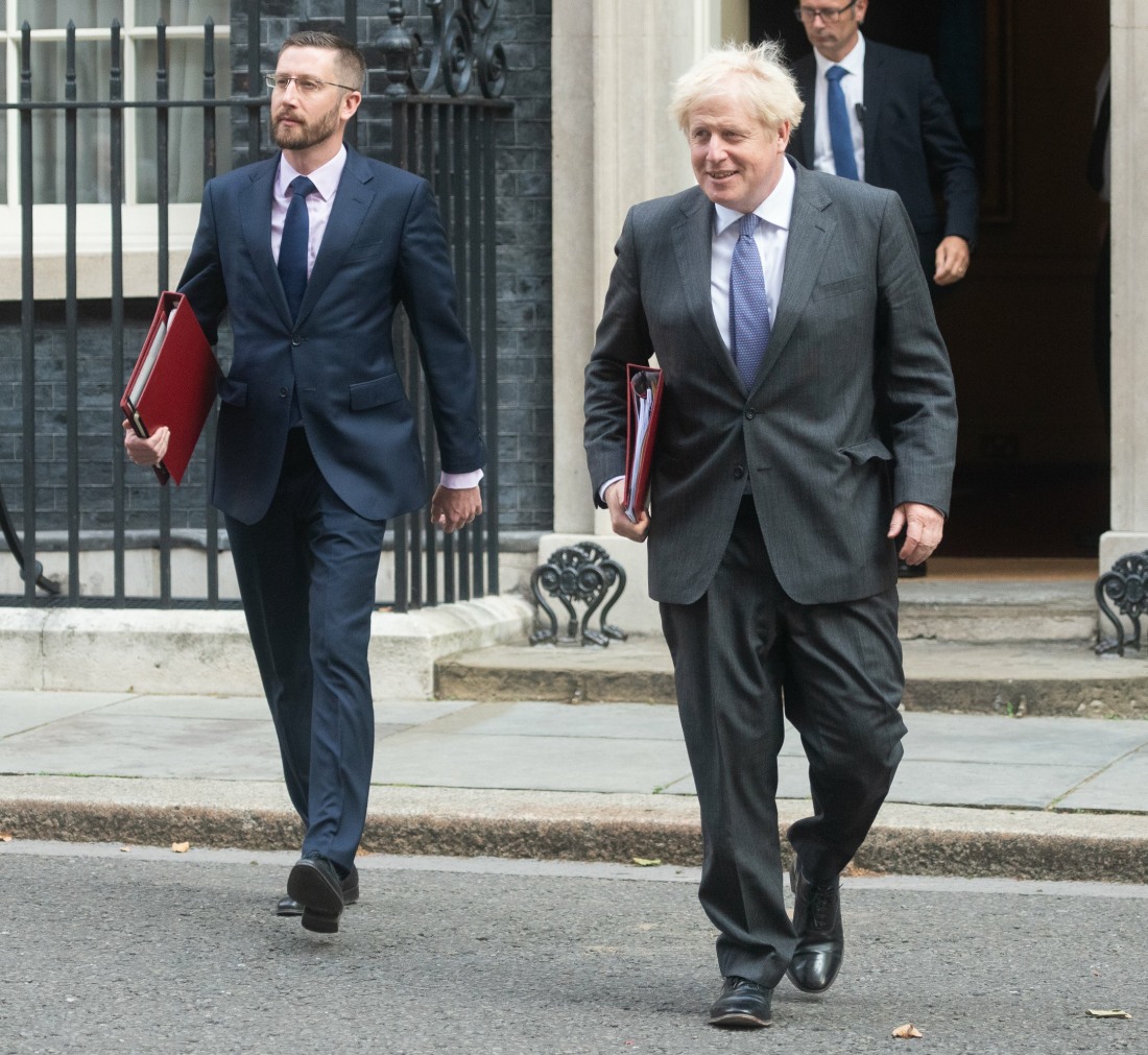 British Prime Minister Boris Johnson walks with Cabinet Office Permanent Undersecretary Simon Case t...