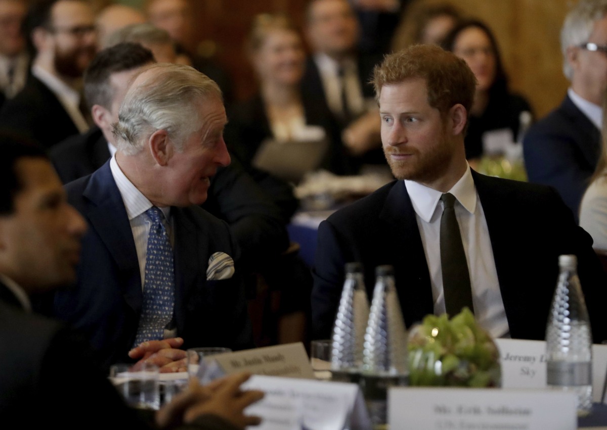Britain's Prince Harry sits with his father Prince Charles, accompanying him to attend a coral reef health and resilience meeting with speeches and a reception with delegates at Fishmongers Hall in London, Wednesday, Feb. 14, 2018. The event held Wednesda