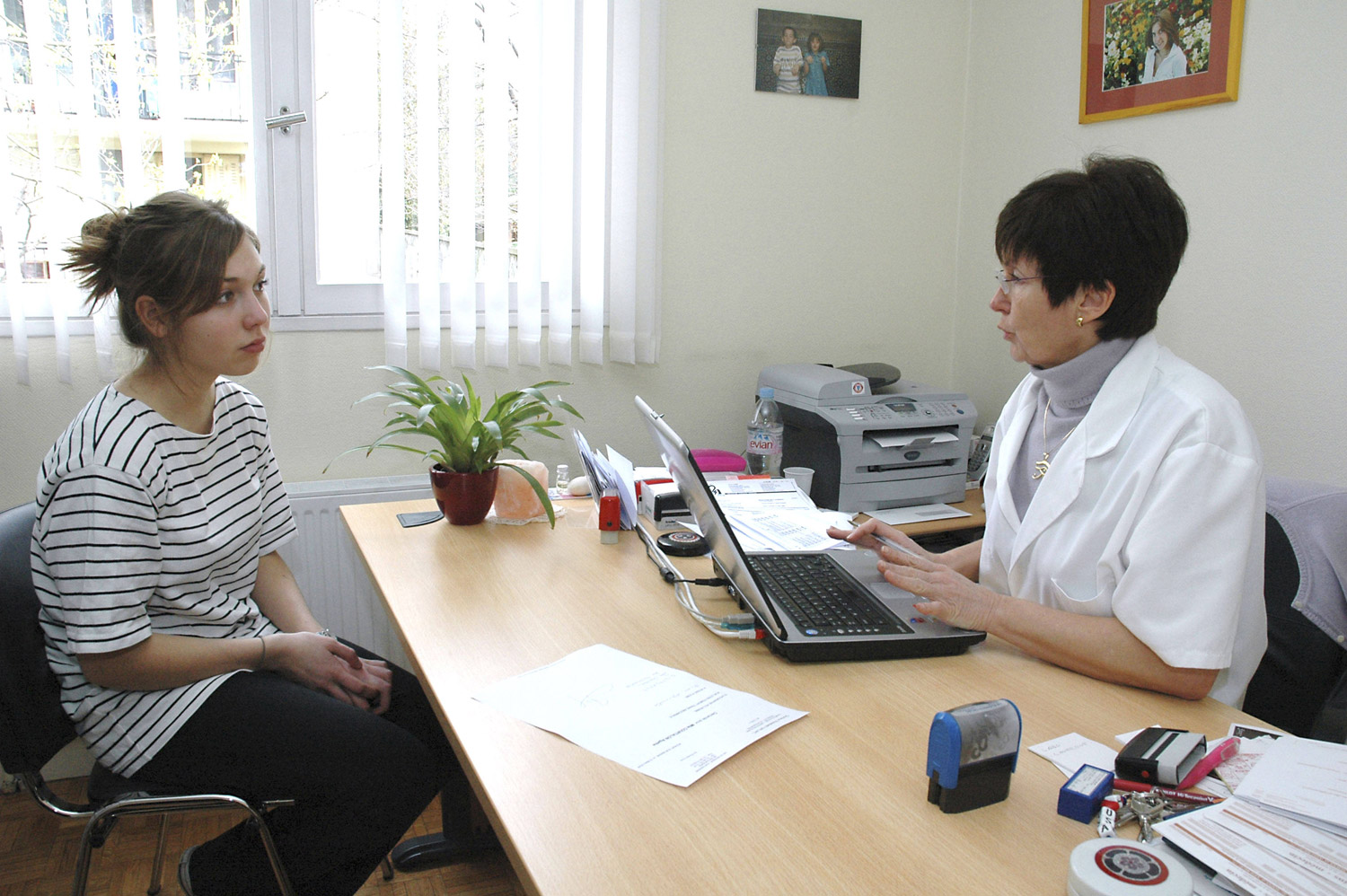 Young woman consults with doctor at desk