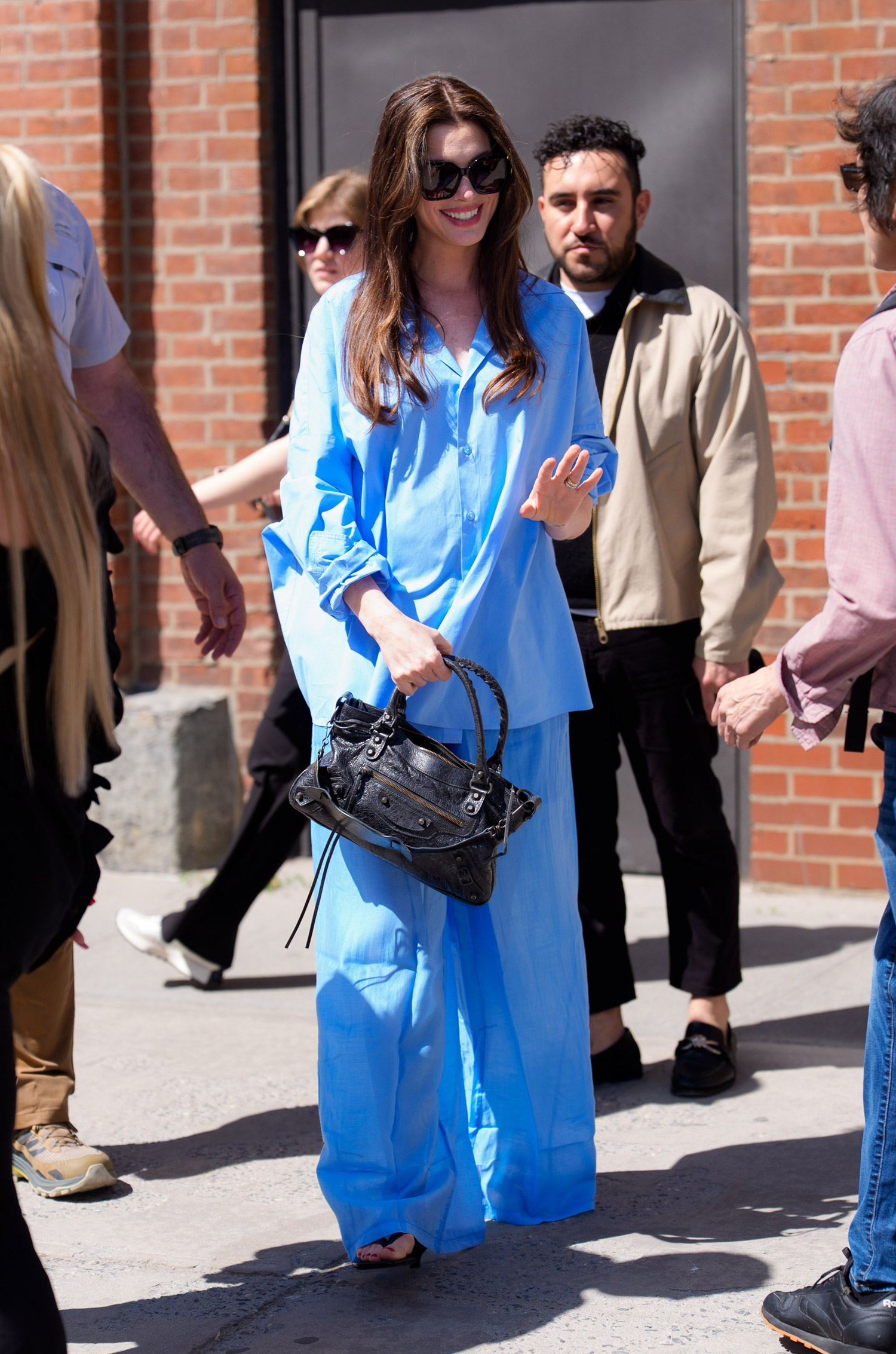 Anne Hathaway, in an all-blue ensemble, greets fans outside a hotel in Manhattan, 6-1-26
