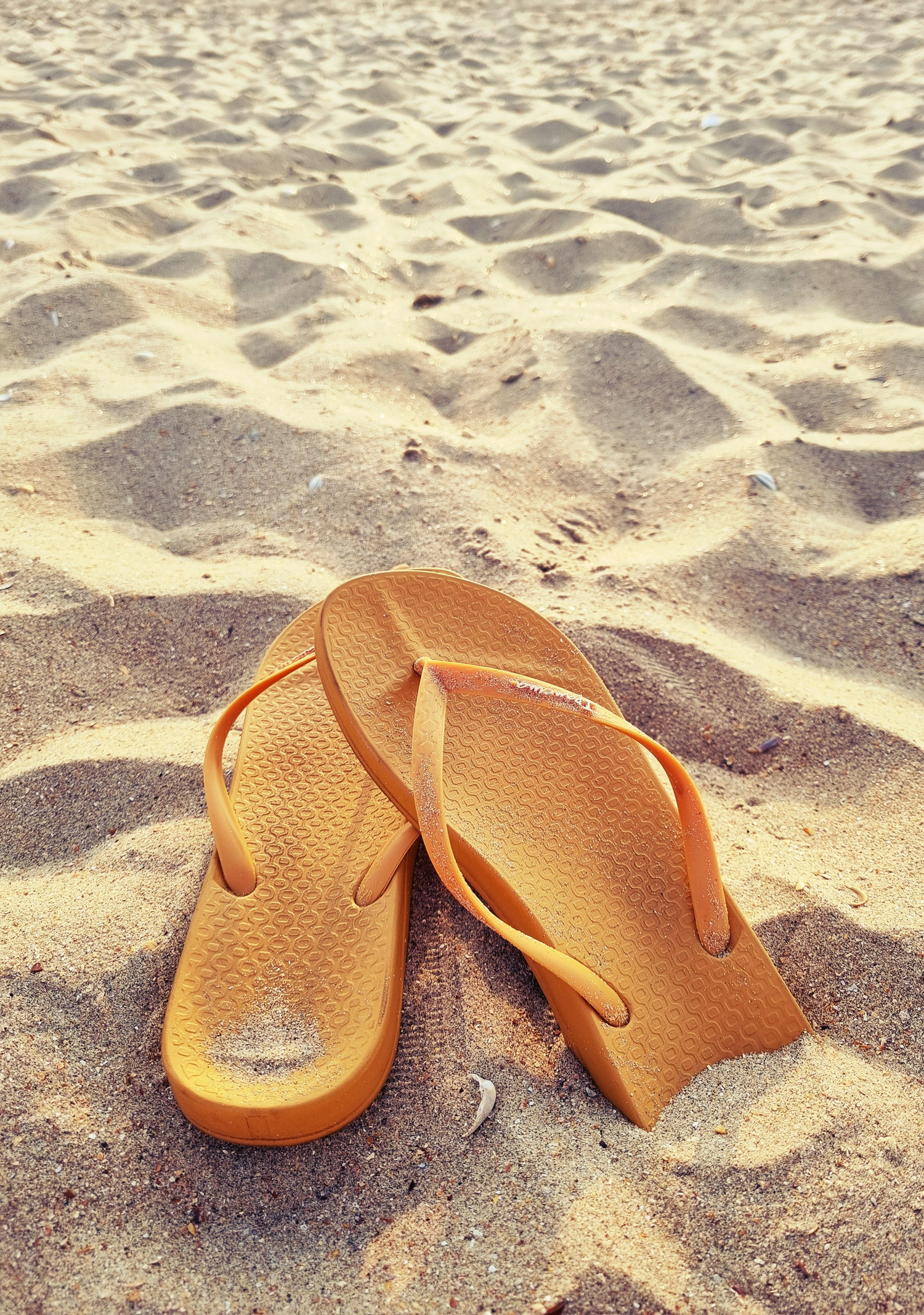 yellow flip flops in the sand