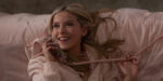 Lexi Minetree in a scene from Elle lying in bed talking on a corded phone with a clear case