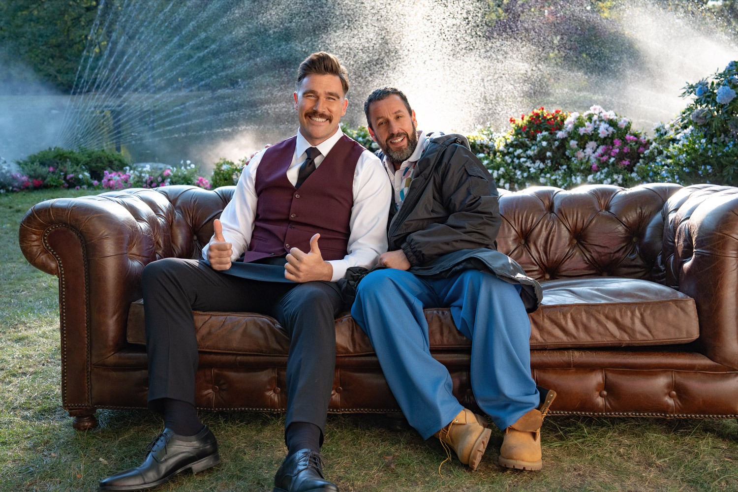 Travis Kelce and Adam Sandler on a couch in a a BTS photo from Happy Gilmore 2
