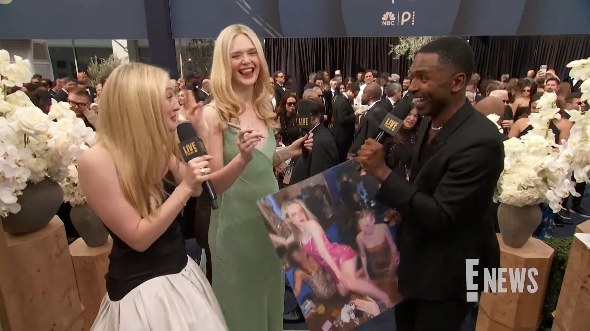 Dakota and Elle sign a poster sized photo of them partying