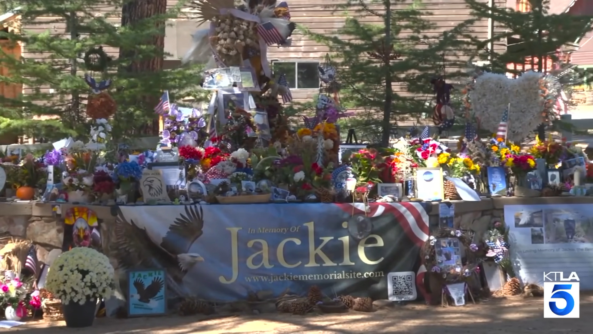 Memorial for Jackie featuring flowers, momentos and a large banner