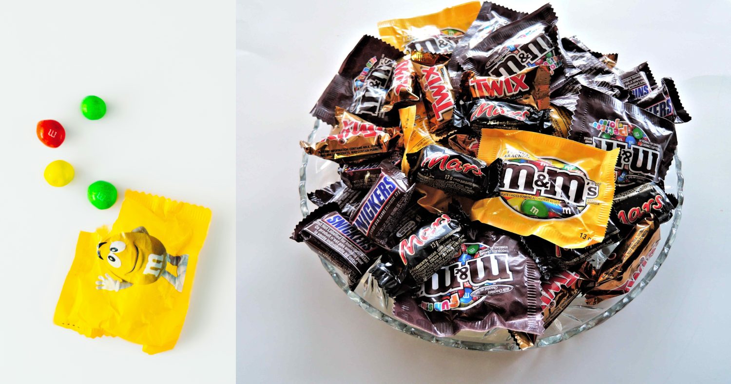 Open packet of M&M snack size next to a photo of a bowl of Halloween candy with M&Ms in it