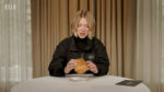 Lea Seydoux looking skeptically at a pain au chocolate