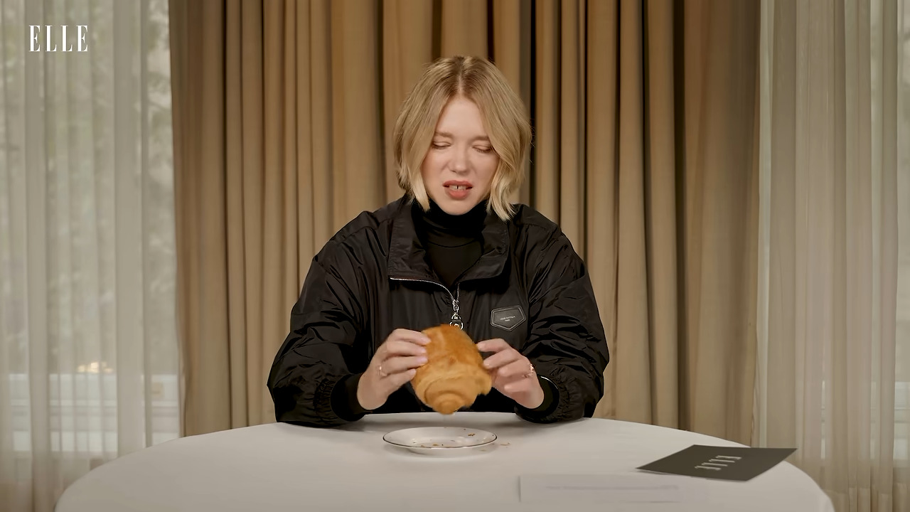 Lea Seydoux looking skeptically at a pain au chocolate