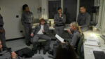 Prison guards in control room plotting