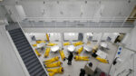 above view of prisoners on ground in prison common area with guards around. Episode 102 of THE NEW STANFORD PRISON EXPERIMENT. Cr. Courtesy of Netflix. © 2026