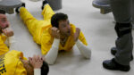 Prisoner on ground with his head raised looking shocked