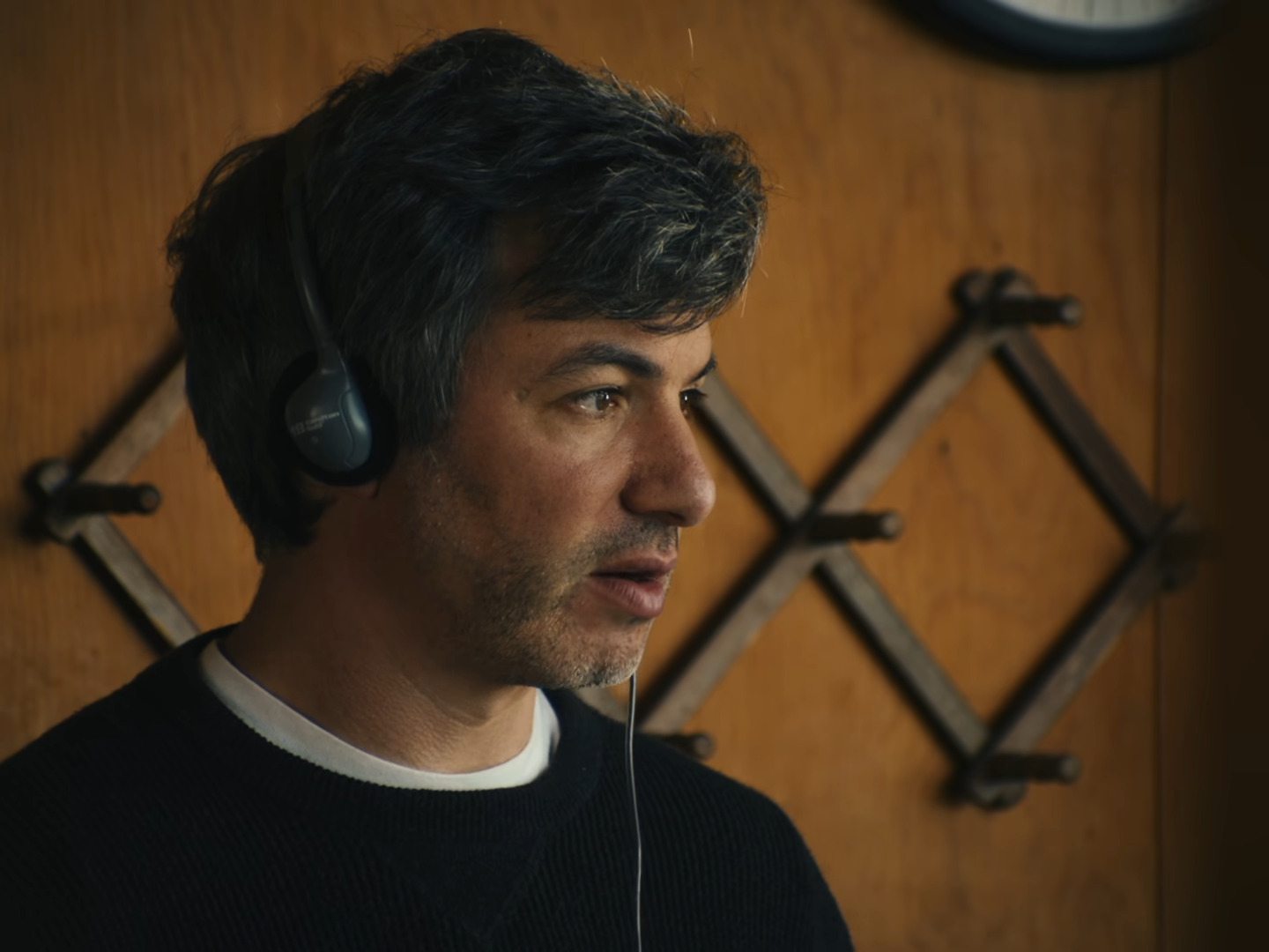 Nathan Fielder with headphones on looking concerned