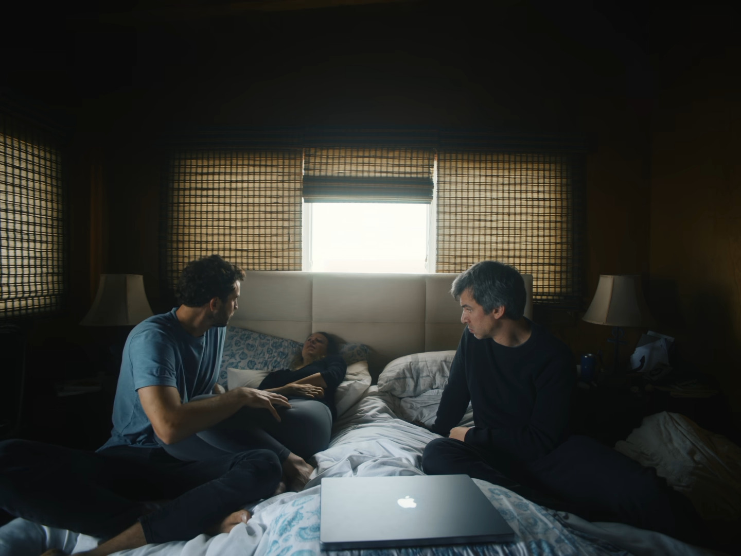 Elizabeth Holmes lying in bed with Nathan Fielder and Billy Evans on either side of her