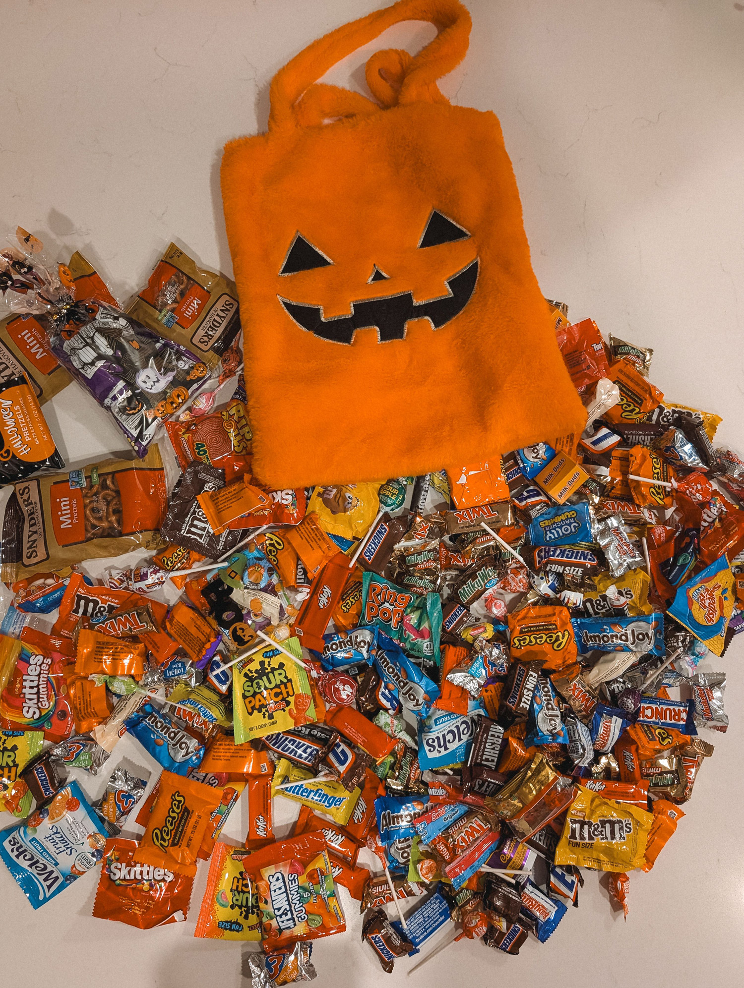 Bag of Hallwoeen candy dumped out with snack size candies on the floor